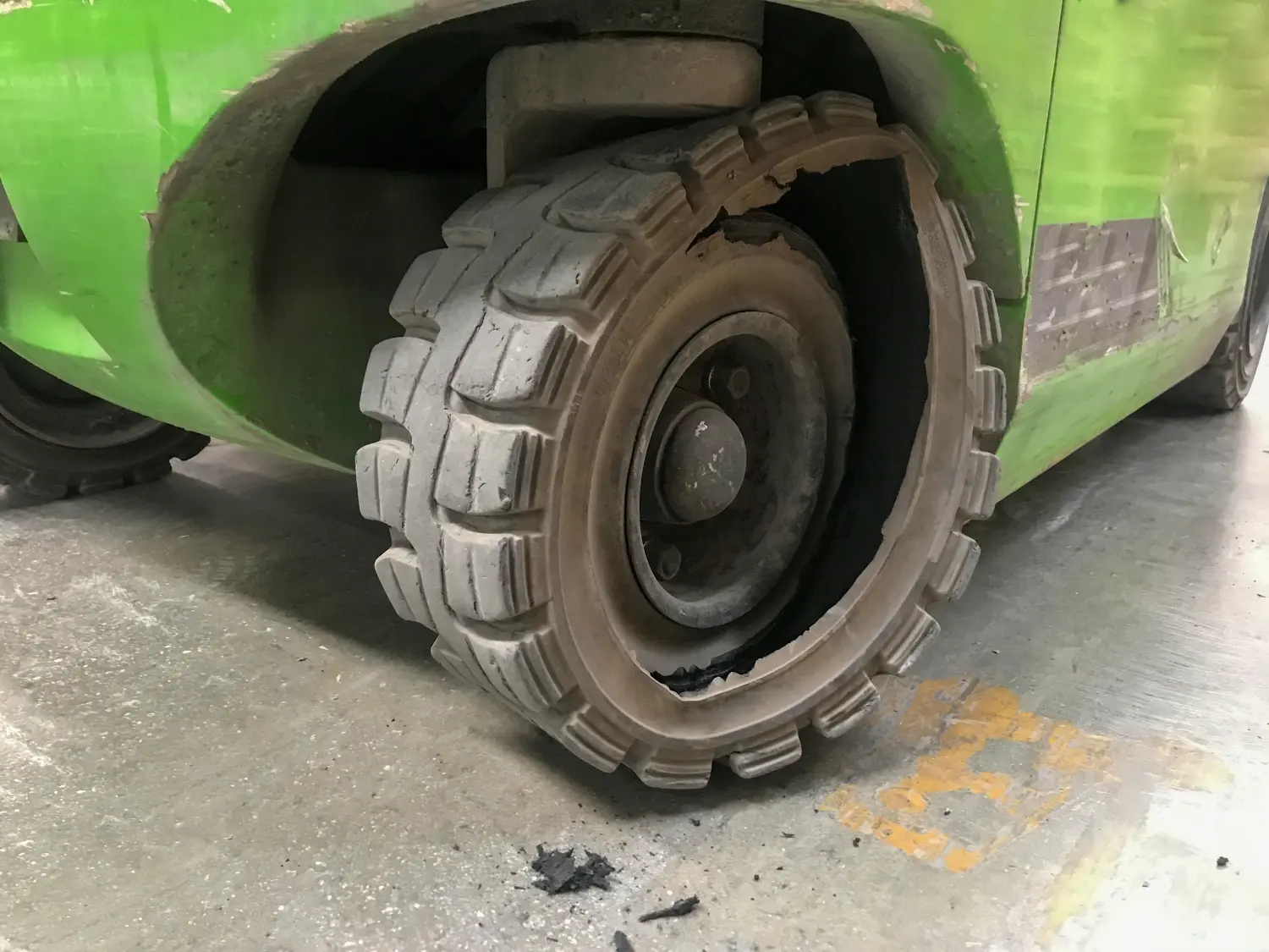 Nahaufnahme eines kaputten Vollreifens eines Gabelstaplers.